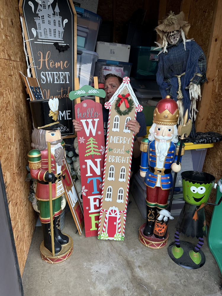 Lou, founder of Unstore Decor, buried in holiday decor in his garage